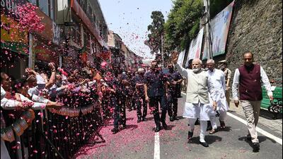 People shower flowers on Prime Minister Narendra Modi as he walk on the Mall Road in Shimla on Tuesday. Himachal governor Rajendra Vishwanath Arlekar and chief minister Jai Ram Thakur are also seen. (ANI)