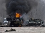 A Russian armored personnel carrier burns amid damaged and abandoned light utility vehicles after fighting in Kharkiv, Ukraine, Feb. 27, 2022. (AP Photo/Marienko Andrew)