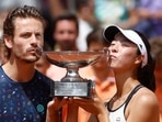Japan's Ena Shibahara, right, and Netherlands' Wesley Koolhof kiss the cup after defeating Belgium's Joran Vliegen and Norway's Ulrikke Eikeri