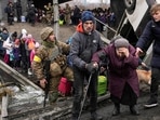 An elderly woman is assisted to cross the Irpin River on an improvised path under a bridge that was destroyed by Ukrainian troops to slow the Russian military advance while fleeing the town of Irpin, Ukraine, Saturday, March 5, 2022. (AP Photo/Vadim Ghirda, File)