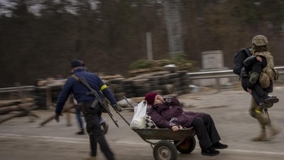 A Ukrainian soldier and a militia man help a fleeing family to cross the Irpin River on the outskirts of Kyiv, Ukraine, Saturday, March 5, 2022. (AP Photo/Emilio Morenatti) A Ukrainian soldier and a militia man help a fleeing family to cross the Irpin River on the outskirts of Kyiv, Ukraine, Saturday, March 5, 2022. (AP Photo/Emilio Morenatti)