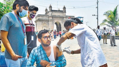 A healthcare worker administers a dose of Covid-19 vaccine to a beneficiary, at Gateway of India in Mumbai on Tuesday. (PTI)