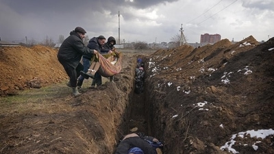 Bodies are placed into a mass grave on the outskirts of Mariupol, Ukraine, Wednesday, March 9, 2022. (AP Photo/Evgeniy Maloletka) Bodies are placed into a mass grave on the outskirts of Mariupol, Ukraine, Wednesday, March 9, 2022. (AP Photo/Evgeniy Maloletka)