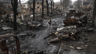 A woman navigates a debris-filled street where destroyed Russian military vehicles stand in Bucha on the outskirts of Kyiv, Ukraine, Sunday, April 3, 2022. (AP Photo/Rodrigo Abd) A woman navigates a debris-filled street where destroyed Russian military vehicles stand in Bucha on the outskirts of Kyiv, Ukraine, Sunday, April 3, 2022. (AP Photo/Rodrigo Abd)