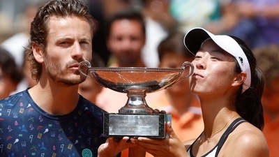 Japan's Ena Shibahara, right, and Netherlands' Wesley Koolhof kiss the cup after defeating Belgium's Joran Vliegen and Norway's Ulrikke Eikeri (AP)