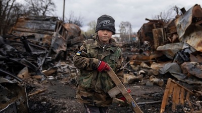 Yehor, 7, holds a toy rifle next to destroyed Russian military vehicles near Chernihiv, Ukraine, (AP Photo/Evgeniy Maloletka) (AP) Yehor, 7, holds a toy rifle next to destroyed Russian military vehicles near Chernihiv, Ukraine, (AP Photo/Evgeniy Maloletka) (AP)