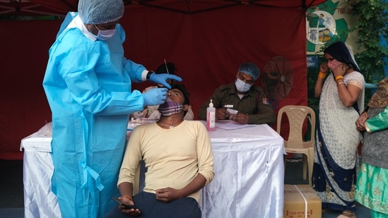 A person takes an RT-PCR test before receiving a dose of the Covid-19 vaccine at a vaccination center.(Bloomberg) A person takes an RT-PCR test before receiving a dose of the Covid-19 vaccine at a vaccination center.(Bloomberg)