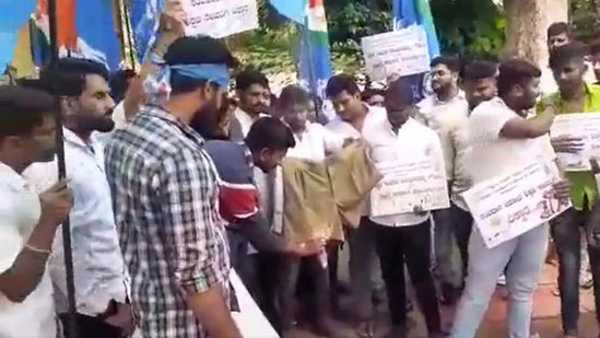 NSUI members lit a pair of khaki shorts on fire in front of Karnataka Education Minister B C Nagesh's home in Tumkur on Wednesday in protest of revisions made to school textbooks.