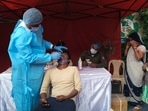 A person takes an RT-PCR test before receiving a dose of the Covid-19 vaccine at a vaccination center.
