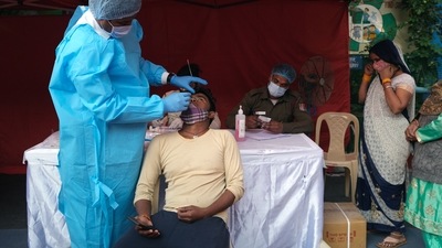 A person takes an RT-PCR test before receiving a dose of the Covid-19 vaccine at a vaccination center. (Bloomberg) A person takes an RT-PCR test before receiving a dose of the Covid-19 vaccine at a vaccination center. (Bloomberg)