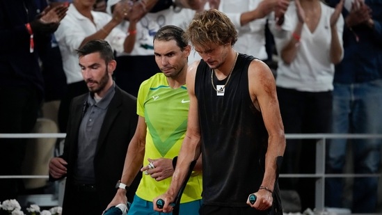 Rafael Nadal walks alongside Germany's Alexander Zverev who retired with an ankle injury in the semifinal match (AP)