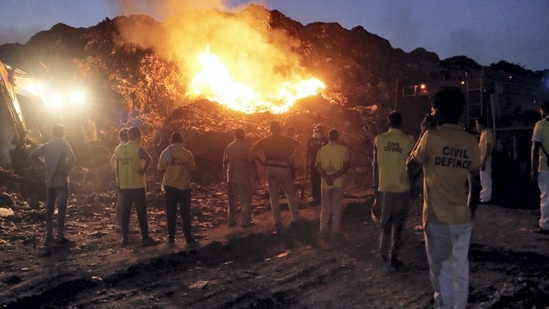 New Delhi: People look on as smoke billows from a fire at Bhalswa landfill, in New Delhi, Friday, June 3, 2022. (PTI Photo)