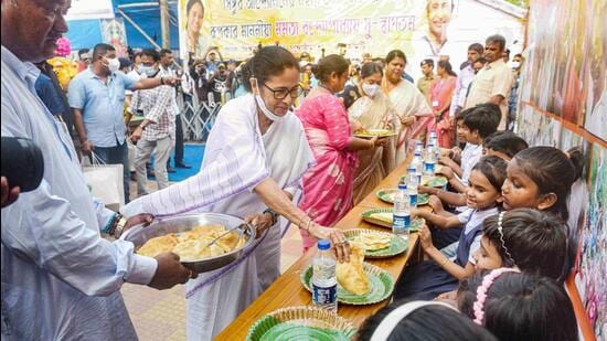 West Bengal chief minister Mamata Banerjee distributes food among students at Singur in Hooghly district. (PTI PHOTO.)