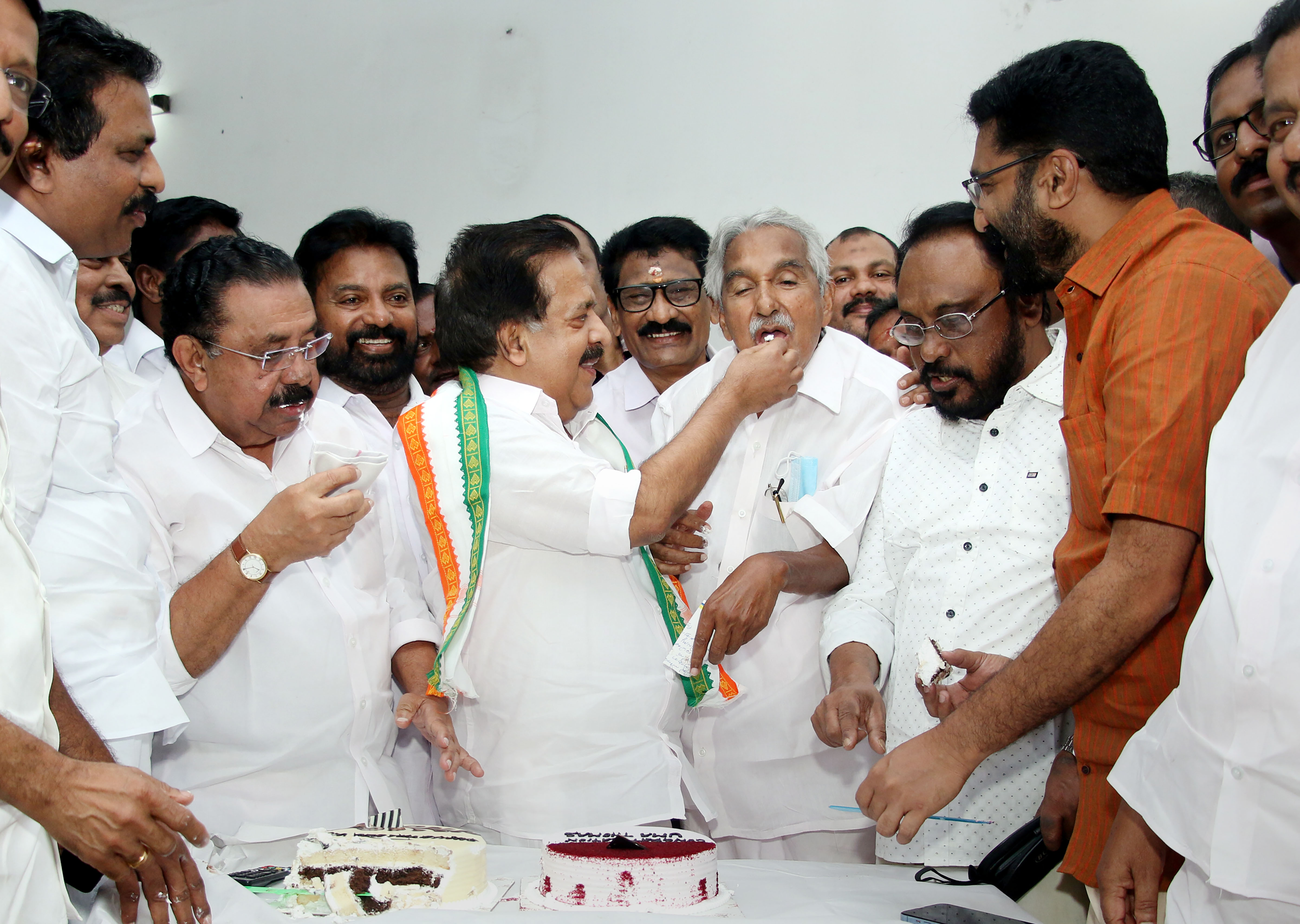 Senior Congress leader Ramesh Chennithala offers a piece of cake to former chief minister Oommen Chandy as they celebrate their victory in the Thrikkakara by-election, in Thiruvananthapuram, on June 3, 2022.&nbsp; (PTI)