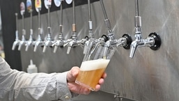 A worker pours a pint of beer at Pressure Drop Brewery, in north London, on May 21, 2022. (Photo by Justin TALLIS/AFP)