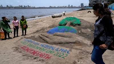 People look at a sand art made for World Environment day in Mumbai. (AP)