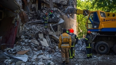 Ukrainian emergency service personnel work outside a damaged building following shelling, in Kharkiv, Ukraine. (AP) Ukrainian emergency service personnel work outside a damaged building following shelling, in Kharkiv, Ukraine. (AP)