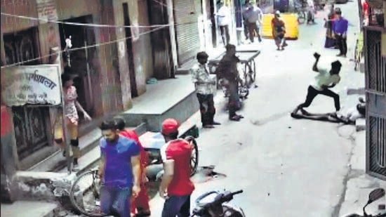 One of the accused hits the victim with a brick. The incident was caught on a CCTV camera. (Sourced)