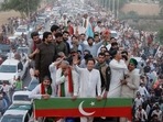 Ousted Pakistani Prime Minister Imran Khan gestures as he travels on a vehicle to lead a protest march in Islamabad, Pakistan.