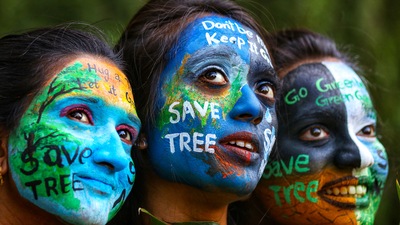 Girls paint their faces with the message of saving the environment, on the eve of the World Environment Day. (PTI)