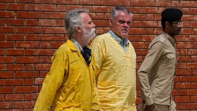 Jim Fitton of Britain, left, and Volker Waldmann of Germany, center, wearing yellow detainees’ uniforms and handcuffed are escorted by Iraqi security forces, outside a courtroom, in Baghdad, Iraq, Sunday. (AP) Jim Fitton of Britain, left, and Volker Waldmann of Germany, center, wearing yellow detainees’ uniforms and handcuffed are escorted by Iraqi security forces, outside a courtroom, in Baghdad, Iraq, Sunday. (AP)
