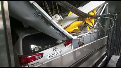 A car was crushed as the car parking lift collapsed at Manik Colony in Kalyan on Monday. Four workers were injured in the mishap. (HT PHOTO)