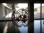 The United Nations logo is seen on a window in an empty hallway at United Nations headquarters.
