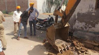 MC team snapping the water and sewerage connection of an illegal colony near Amar Sweet Shop on Churpur Road in Ludhiana. (HT PHOTO)