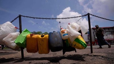 Empty vessels are tied up in a line to secure positions of a queue for buying kerosine oil outside a fuel station in Colombo. (AP) Empty vessels are tied up in a line to secure positions of a queue for buying kerosine oil outside a fuel station in Colombo. (AP)