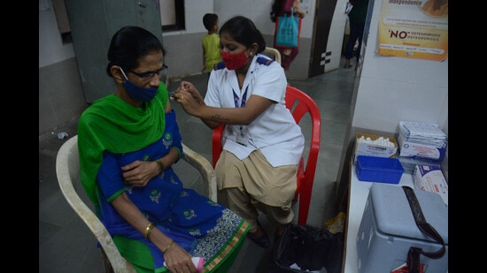 A beneficiary takes her booster dose in Thane district on Tuesday. As Covid cases rise, Kalyan Dombivli Municipal Corporation has appealed to citizens to take booster dose. (PRAFUL GANGURDE/HT PHOTO)