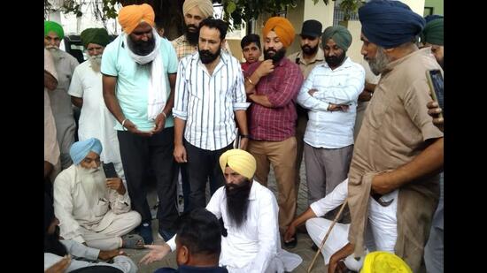 Cane farmers gheraoing AAP MLA from Amargarh constituency Jaswant Singh Gajjan Majra at Kheri Jattan village on Tuesday. (HT Photo)