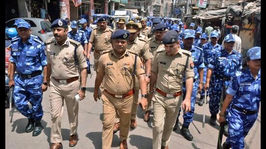 Police and Rapid Action Force (RAF) personnel patrol the Parade Chauraha area on Monday after violence broke out between two groups on June 3, in Kanpur. (ANI Photo)