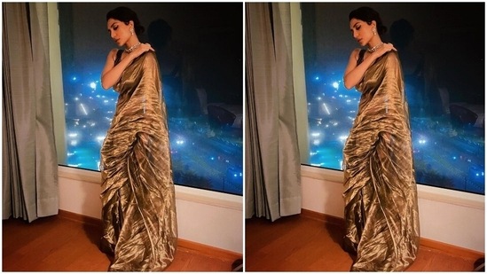 The six yards features metallic zari selvedge all around the borders and crumpled fabric texture. Sobhita teamed it with a printed black blouse adorned with golden embroidered stripes, a plunging neckline, bare back detail, and a cropped hem flaunting her midriff.(Instagram)
