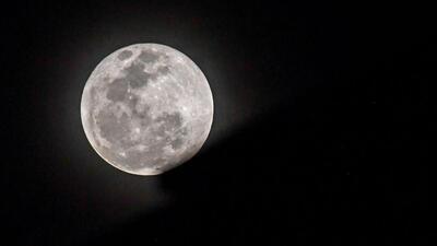 The full moon rises behind an apartment building during lunar eclipse in Singapore. (AFP) The full moon rises behind an apartment building during lunar eclipse in Singapore. (AFP)