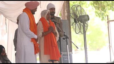Balkaur Singh and Charan Kaur, the parents of Punjabi singer Sidhu Moose Wala, addressing the gathering at his bhog ceremony organised at the New Grain Market in Mansa on Wednesday. (Sanjeev Kumar/HT)