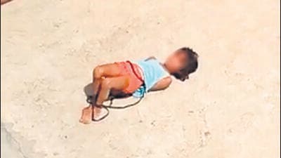 A video grab shows the girl, her hands and legs tied, on the terrace of her home in northeast Delhi’s Khajuri Khas. (Sourced) A video grab shows the girl, her hands and legs tied, on the terrace of her home in northeast Delhi’s Khajuri Khas. (Sourced)