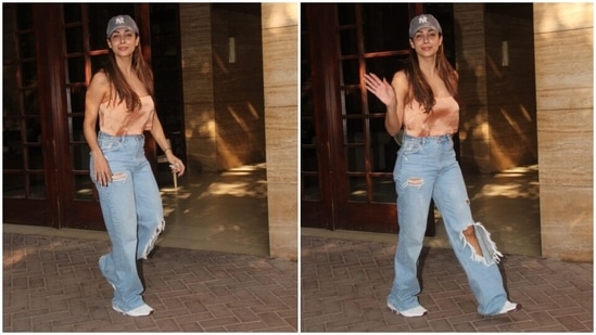 Malaika styled her day-out outfit with white chunky lace-up sneakers, a grey baseball NY cap, open tresses, glossy lip shade and a bare glowing face. Her metallic gold nail paint added a touch of drama to the ensemble.(HT Photo/Varinder Chawla)