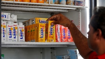 A worker arranges Amul drinks at an Amul cafe in Ahmedabad, India. (REUTERS)