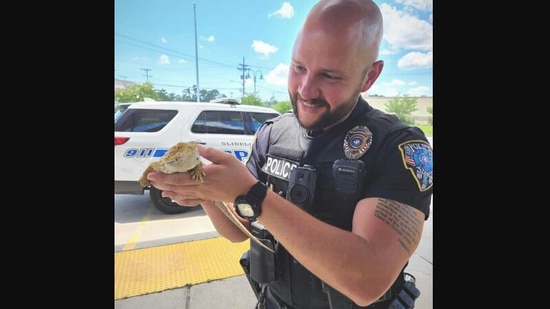 The picture shows the policeman with the rescued animal that people though was an iguana.(Facebook/@Slidell Police Department)