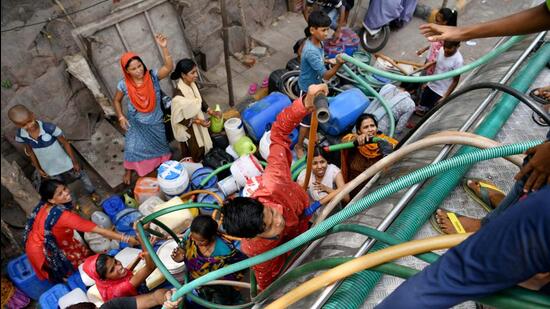 People collect drinking water from a tanker at Sanjay Camp in New Delhi on Thursday. (ANI)