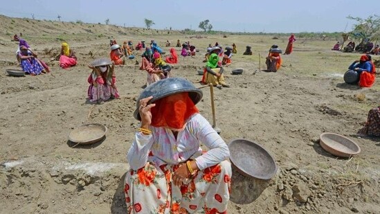 Labourers under MNREGA use mortar pans to protect themselves against the scorching sun, at a worksite on the outskirts of Beawar, Rajasthan. (PTI file photo)