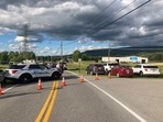 Law enforcement vehicles block the road at the scene of a shooting at a Maryland business near Smithsburg, Md.