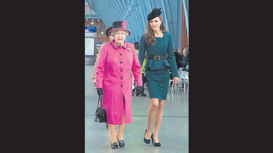 The Queen pairs a hot pink skirt suit with a colour blocked hat, matching bag and gloves as pictured with Kate Middleton. (Photo: AFP, Facebook, Instagram and Twitter)