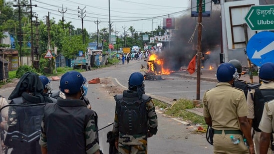 Security personnel try to maintain law and order as a vehicle is allegedly set ablaze by miscreants during a protest over controversial remarks on Prophet Mohammed, in West Bengal's Howrah district on Friday, June 10, 2022. (PTI Photo)