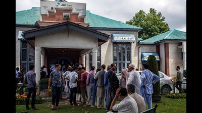 People wait in a queue outside J&K Bank in Srinagar. (ANI Photo) (ANI)