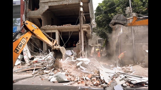 A bulldozer demolishes a building that the police claimed belonged to a close relative of the June 3 Kanpur violence main accused Zafar Hayat Hashmi, on Saturday. (ANI)