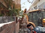Bulldozer razing the house of Javed Mohammad aka Javed Pump.(HT Photo)