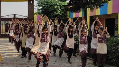 Students participating in a yoga exercise during a summer camp at the government school in Jaspal Banger, Ludhiana. (HT Photo)