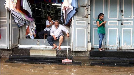 A-shopkeeper-in-Dadar-s-Hindmata-cleans-the-entrance-of-his-shop-as-heavy-rains-caused-flooding-and-waterlogging-in-Mumbai-Kunal-Patil-HT-photo