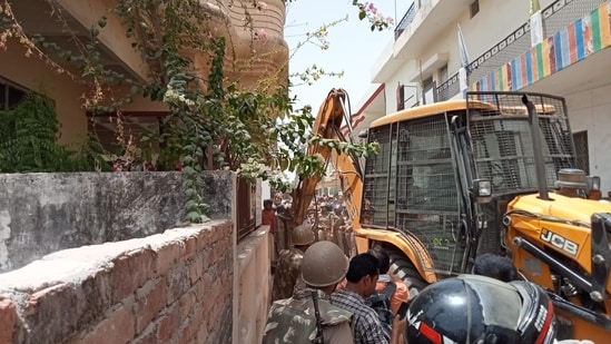 Bulldozer razing the house of Javed Mohammad aka Javed Pump.(HT Photo)